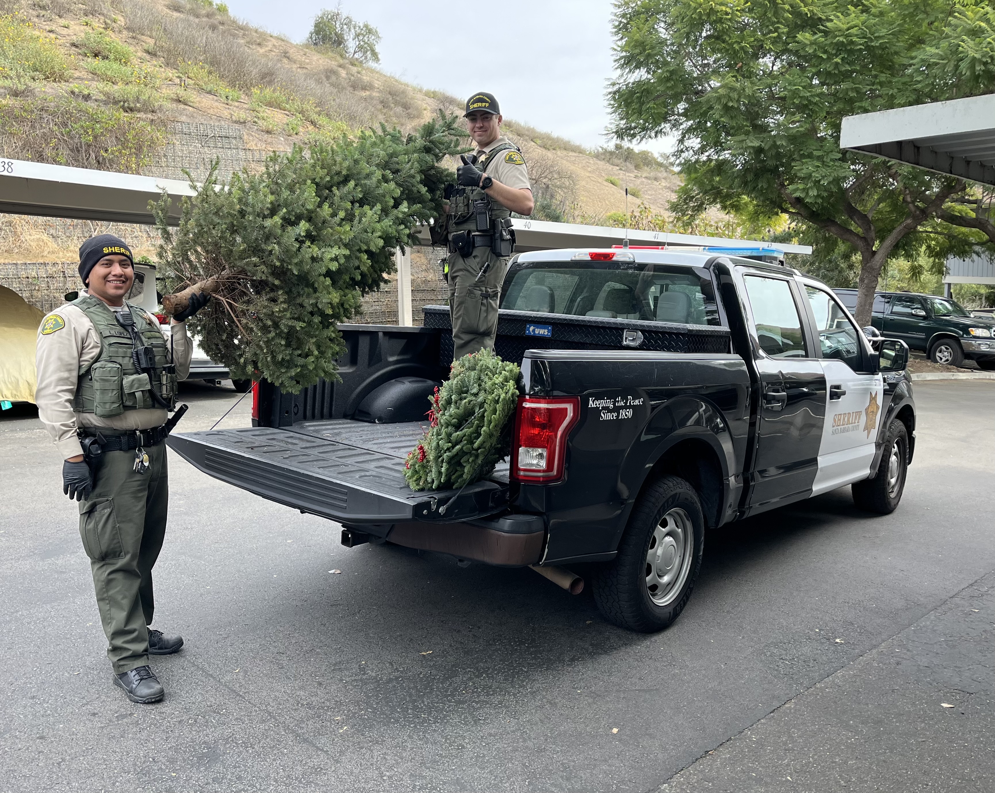 Santa Barbara County Sheriff's deputies pose with a stolen Christmas tree that was recovered on Dec. 11, 2024. (Santa Barbara County Sheriff's Office)