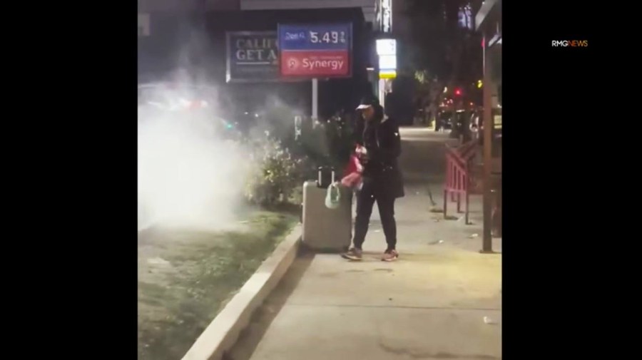 A bystander with a fire extinguisher intervenes as the suspect set fire to a car at a Hollywood gas station on Dec. 27, 2024. (RMG)