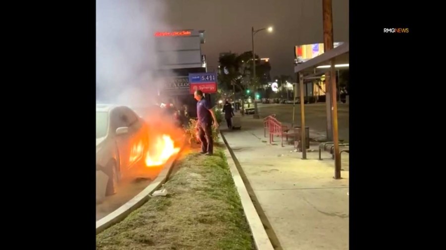 A bystander with a fire extinguisher intervenes as the suspect set fire to a car at a Hollywood gas station on Dec. 27, 2024. (RMG)