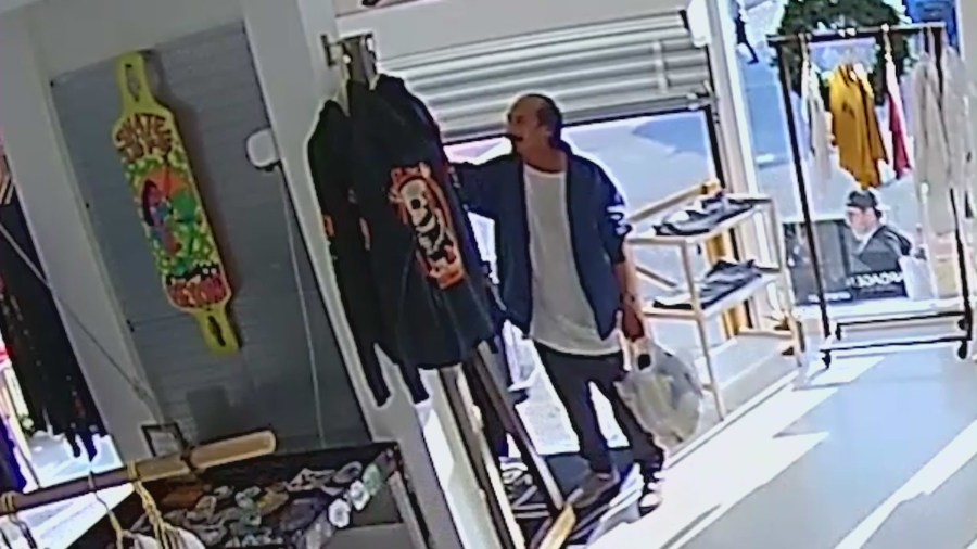 The male suspect is seen stealing a hoodie off a display rack at a clothing boutique in Venice, California on Dec. 28, 2023. (Vardagen)