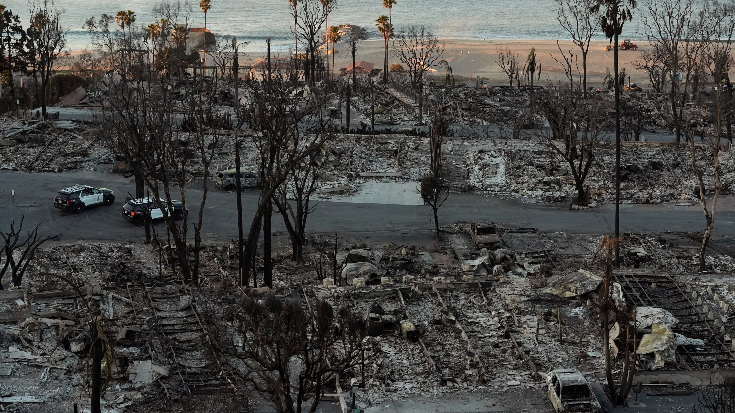 Los Angeles Police guard burned homes at the Pacific Palisades Bowl Mobile Estates destroyed by the Palisades Fire are seen in the Pacific Palisades neighborhood of Los Angeles, Thursday, Jan. 16, 2025. (AP Photo/Damian Dovarganes)