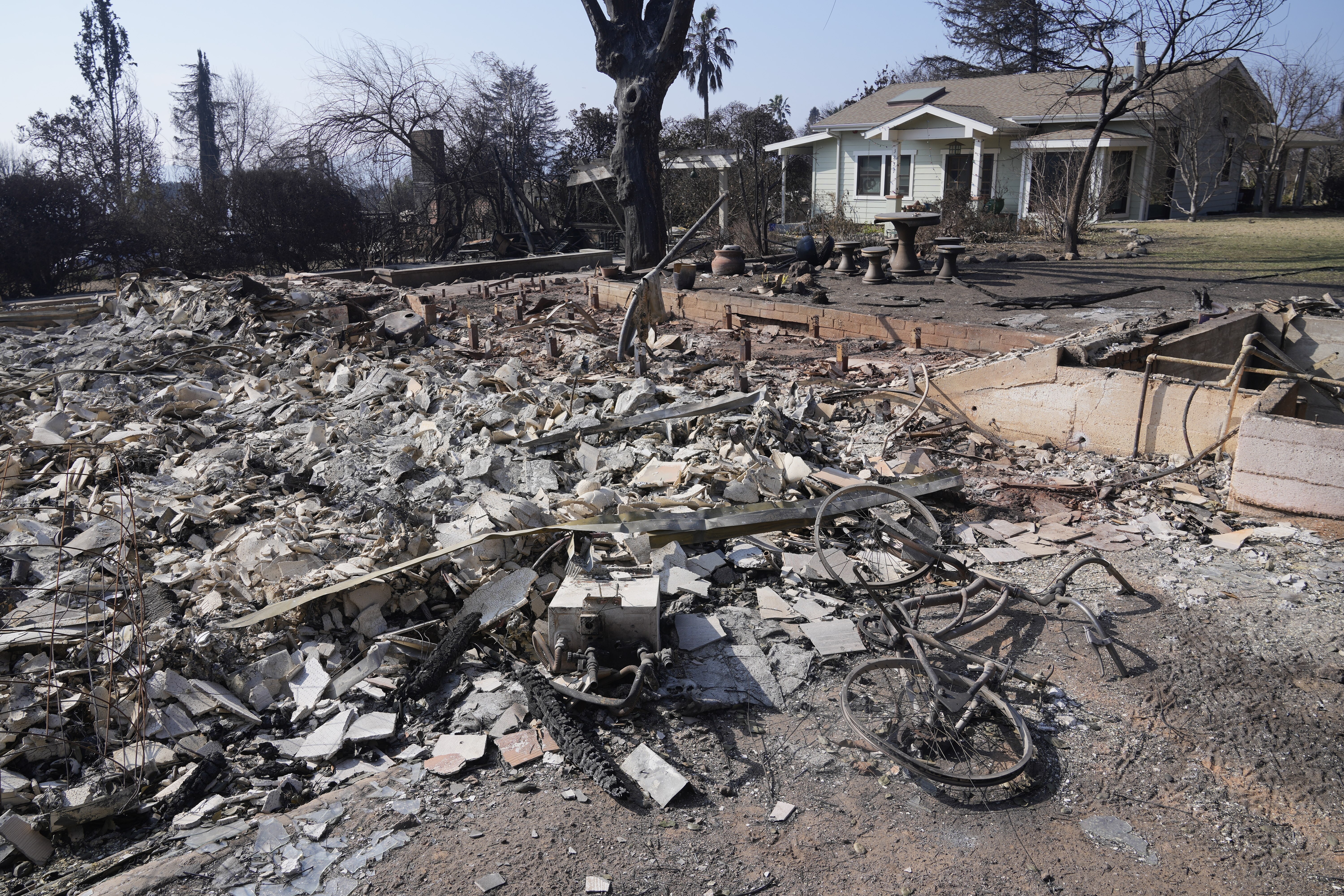 Debris from a destroyed home is seen as a newly built ADU (accessory dwelling unit) stands behind after surviving the Eaton Fire, Sunday, Jan. 19, 2025, in Altadena, Calif. (AP Photo/Damian Dovarganes)