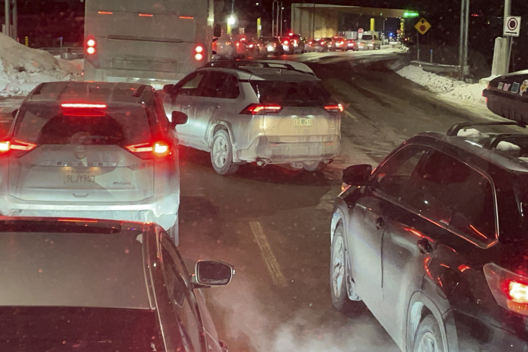 Cars are backed up at the US-Canada border in Stanstead, Quebec, after a shooting involving a U.S. Border Patrol agent in Coventry, Vt., Monday, Jan. 20, 2025. (AP Photo/Chloe Jones)
