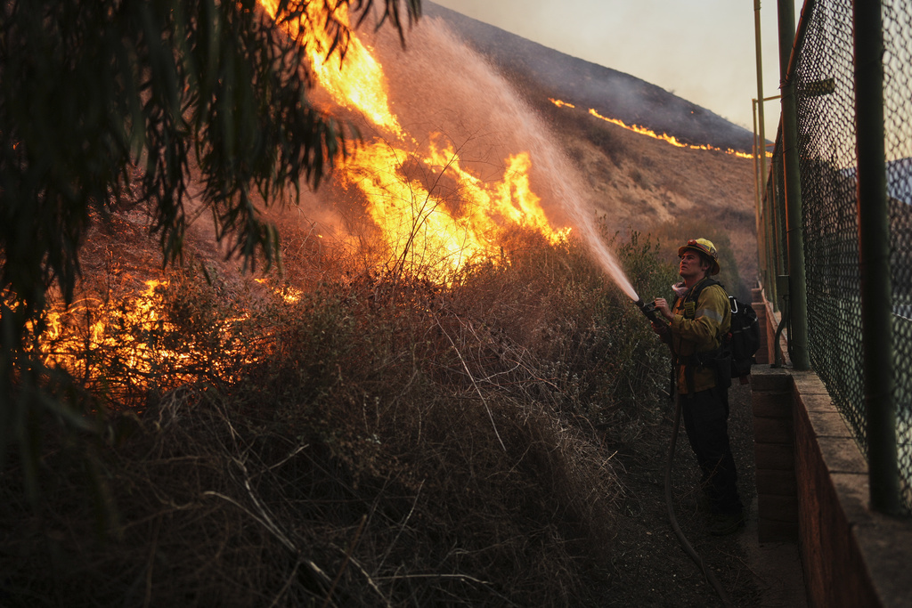 A firefighter battles the Kenneth Fire, Thursday, Jan. 9, 2025, in the West Hills section of Los Angeles. (AP Photo/Eric Thayer)