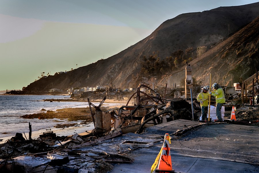 A crew for Southern California Edison prepares the ground for electric poles along the Pacific Coast Highway near homes destroyed from the Palisades Fire in Malibu, Calif., Wednesday. Jan. 15, 2025. (AP Photo/Richard Vogel)