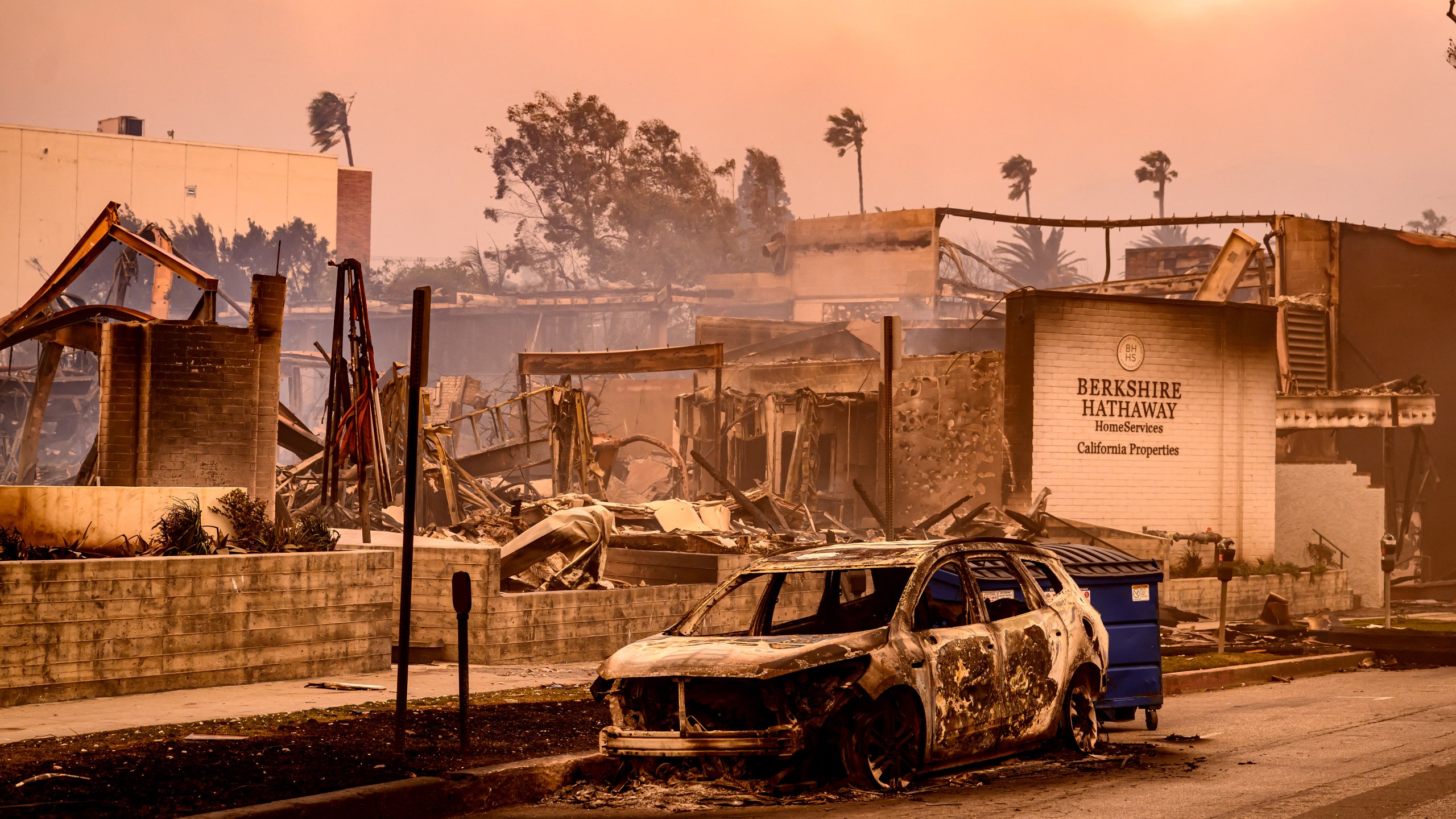 A Berkshire Hathaway office is left in smoldering ashes during the Palisade fire in the Palisade village area Pacific Palisades, a neighborhood of Los Angeles, California, January 8, 2025. The terrifying blazes leveled whole streets, torching cars and houses in minutes. More than 1,000 buildings have burned in multiple wildfires that have erupted around America's second-biggest city, forcing tens of thousands of people from their homes. (Photo by JOSH EDELSON/AFP via Getty Images)