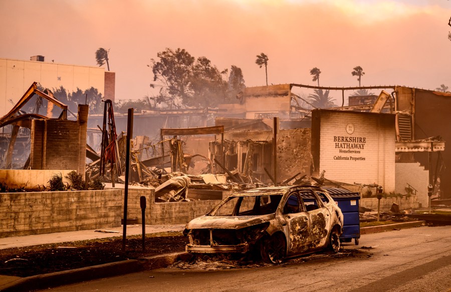 A Berkshire Hathaway office is left in smoldering ashes during the Palisade fire in the Palisade village area Pacific Palisades, a neighborhood of Los Angeles, California, January 8, 2025. The terrifying blazes leveled whole streets, torching cars and houses in minutes. More than 1,000 buildings have burned in multiple wildfires that have erupted around America's second-biggest city, forcing tens of thousands of people from their homes. (Photo by JOSH EDELSON/AFP via Getty Images)