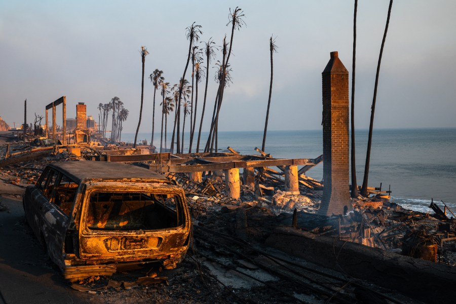 Buildings and cars destroyed by the Palisades fire lay along the Pacific Coast Highway in Malibu, California, on January 8, 2025. At least five people are now known to have died in wildfires raging around Los Angeles, with more deaths feared, law enforcement said January 8, as terrifying blazes leveled whole streets, torching cars and houses in minutes.