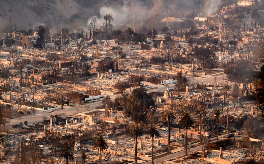 In this aerial view taken from a helicopter, homes burned from the Palisade fire smolder near the Pacific Palisades neighborhood of Los Angeles, California on January 9, 2025. Massive wildfires that engulfed whole neighborhoods and displaced thousands in Los Angeles remained totally uncontained January 9, 2025, authorities said, as US National Guard soldiers readied to hit the streets to help quell disorder. Swaths of the United States' second-largest city lay in ruins, with smoke blanketing the sky and an acrid smell pervading almost every building. (Photo by JOSH EDELSON / AFP) (Photo by JOSH EDELSON/AFP via Getty Images)