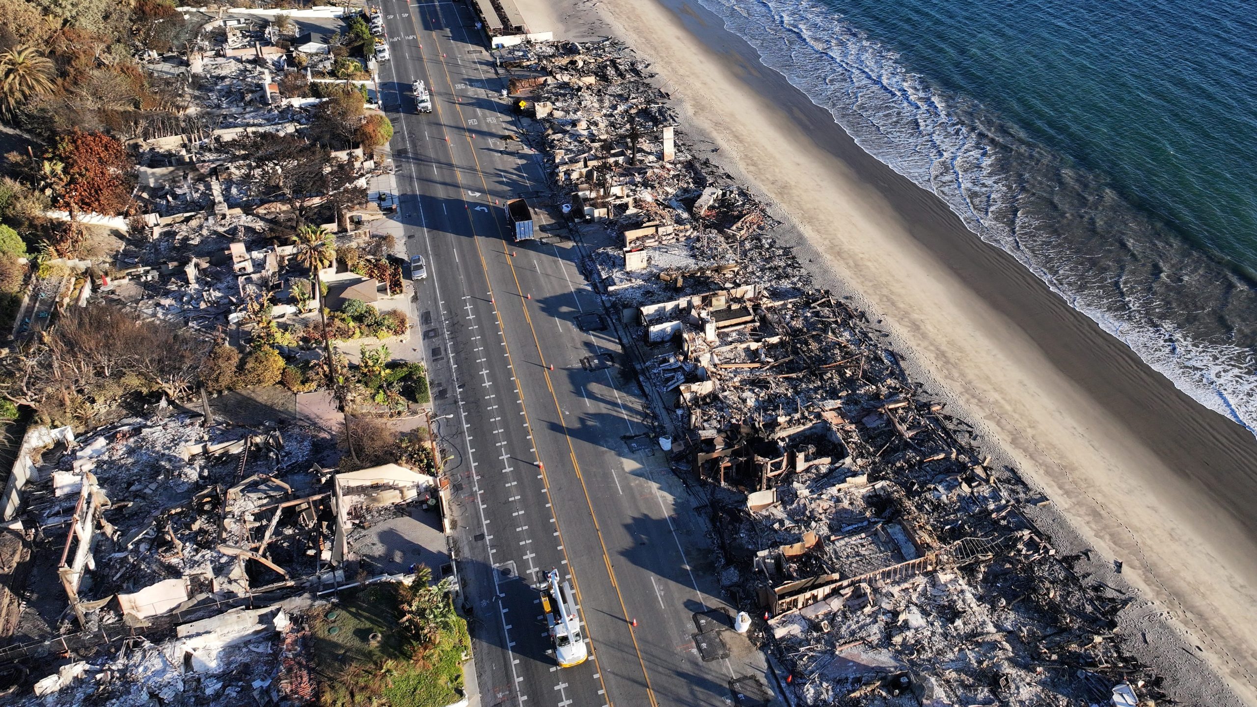 MALIBU, CALIFORNIA - JANUARY 16: An aerial view of a beachside homes destroyed in the Palisades Fire along Pacific Coast Highway as wildfires cause damage and loss through the LA region on January 16, 2025 in Malibu, California. Multiple wildfires which were fueled by intense Santa Ana Winds have burned across Los Angeles County leaving at least 27 dead with over 180,000 people having been under evacuation orders. Over 12,000 structures have been burned in the Palisades and Eaton Fires. (Photo by Mario Tama/Getty Images)