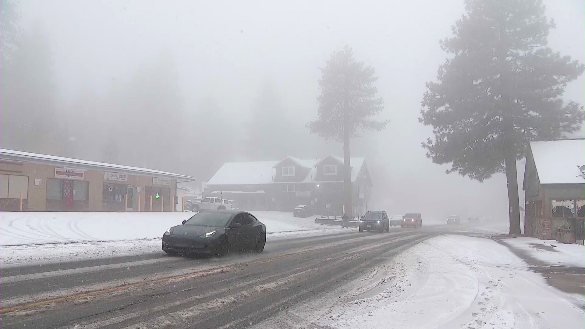 A main road is covered in snow in Running Springs, a community in the San Bernardino mountains. (KTLA)