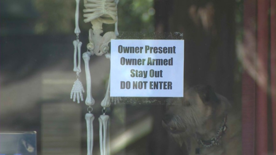 A sign posted on EveAnna Manley's front window alerting potential trespassers that she is armed. (KTLA)