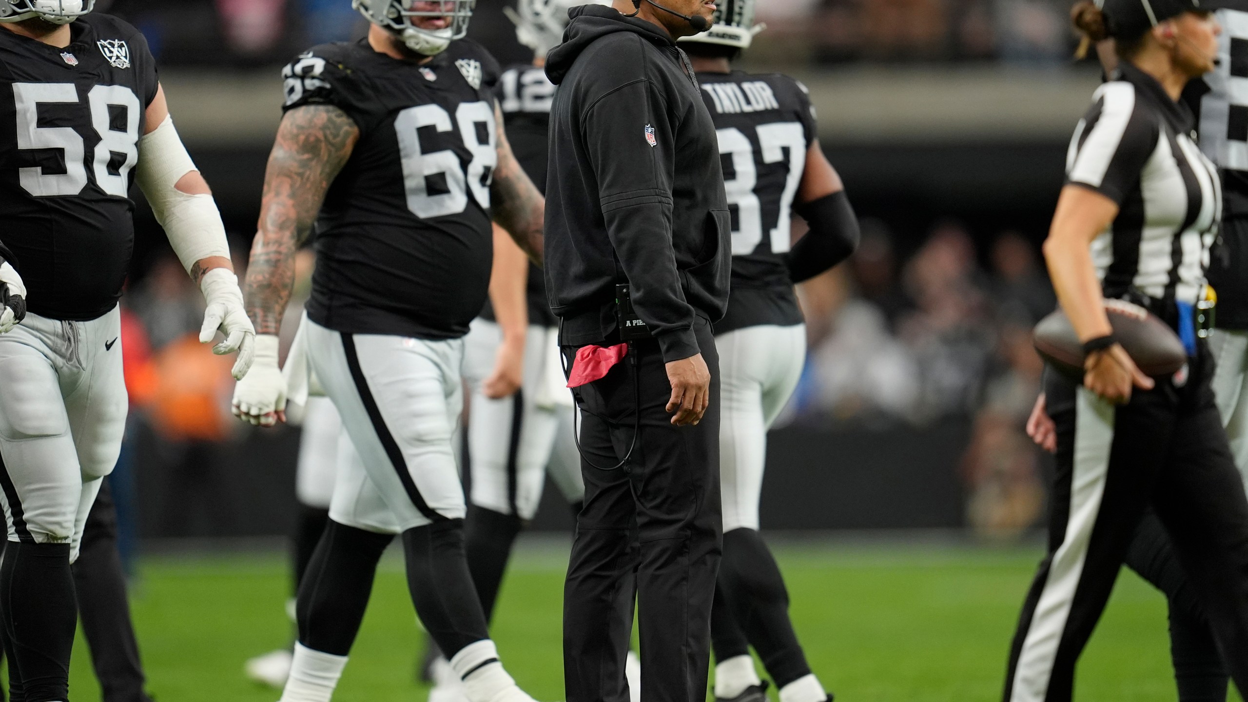 FILE - Las Vegas Raiders head coach Antonio Pierce, center, stands on the field during the first half of an NFL football game against the Los Angeles Chargers, Jan. 5, 2025, in Las Vegas. (AP Photo/Abbie Parr, File)