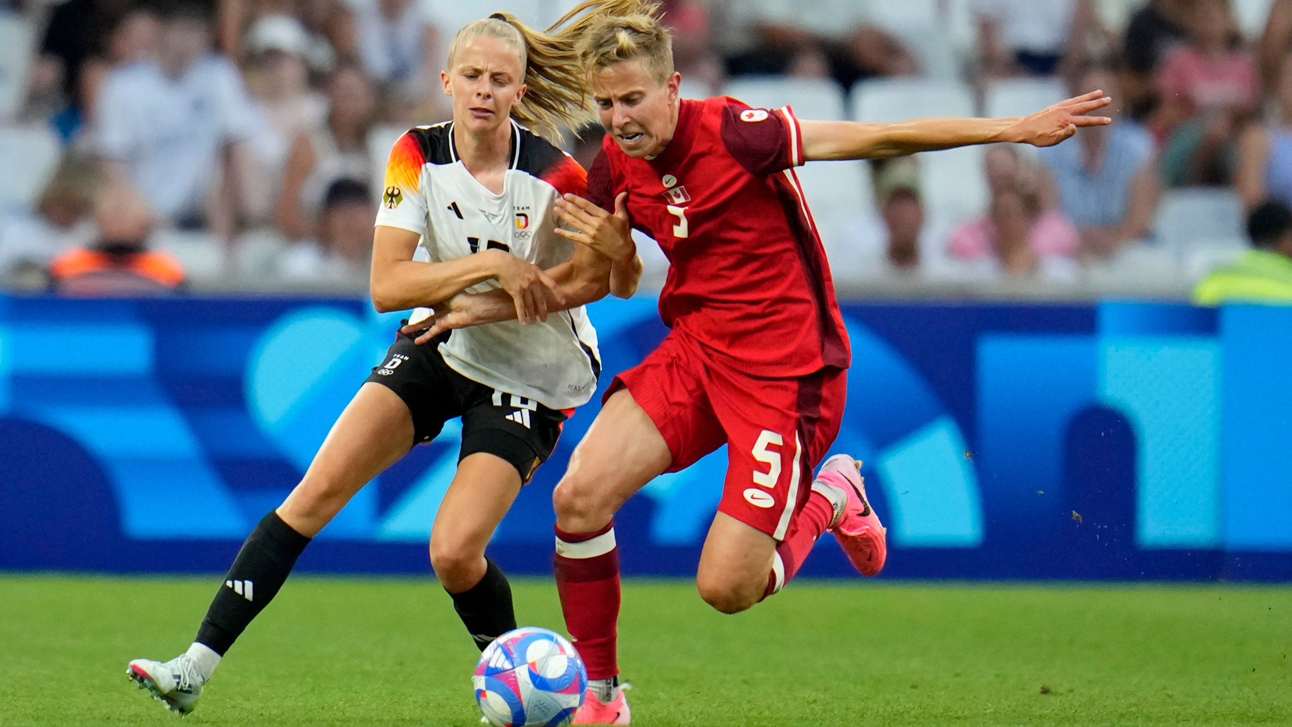 FILE - Germany's Laura Freigang fights for the ball with Canada's Quinn during a women's quarterfinal soccer match between Canada and Germany at the 2024 Summer Olympics, Saturday, Aug. 3, 2024, at Marseille Stadium in Marseille, France. (AP Photo/Julio Cortez, File)