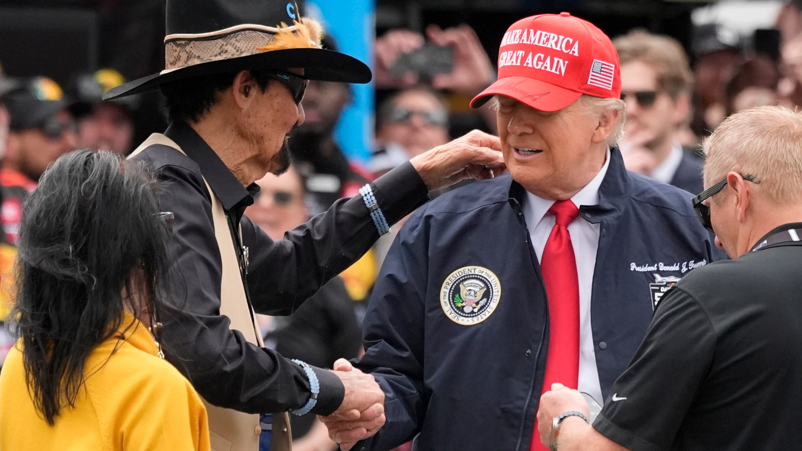 President Donald Trump, right, shakes hands with NASCAR Hall of Fame driver Richard Petty at the NASCAR Daytona 500 auto race at Daytona International Speedway, Sunday, Feb. 16, 2025, in Daytona Beach, Fla. (AP Photo/John Raoux)