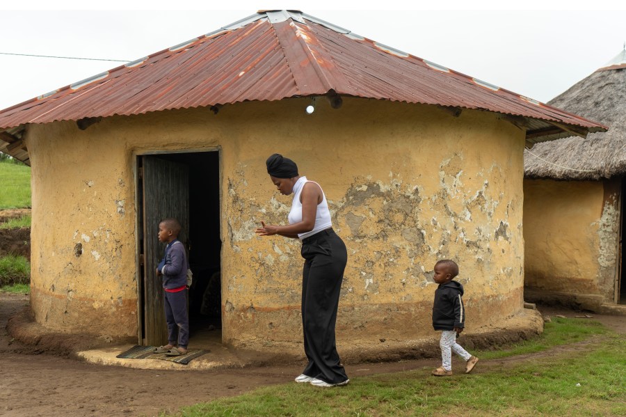 Unemployed 19-year-old South African Nozuko Majola walks with her children at her Umzimkhulu home Tuesday, Feb. 11, 2025, is one of millions of patients in South Africa affected by U.S. President Donald Trump's global foreign aid freeze, raising worries about HIV patients defaulting on treatment. (AP Photo/Jerome Delay}