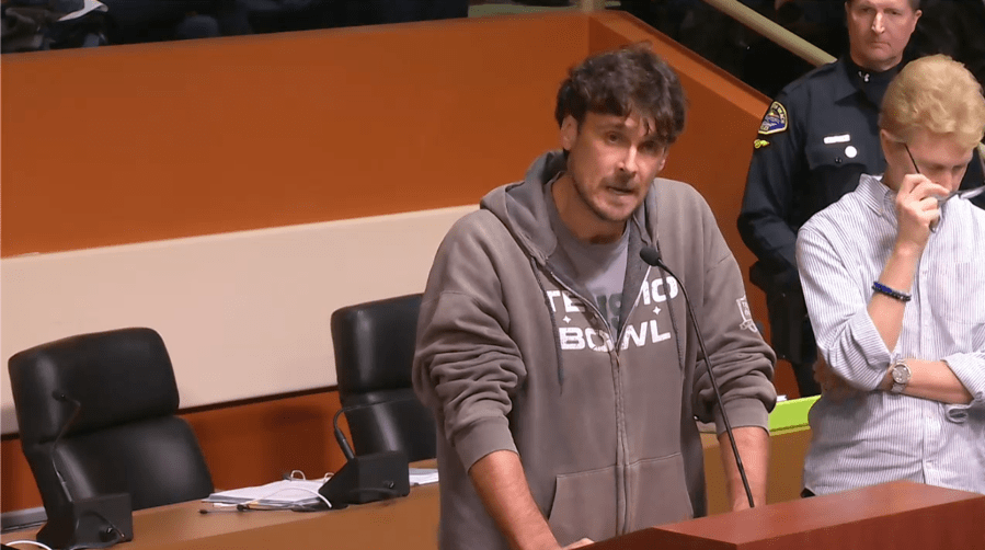 Chris Kluwe, former NFL punter, speaks in opposition to a MAGA-inspired plaque design at Huntington Beach City Council meeting moments before being detained by police on Feb. 18, 2025.