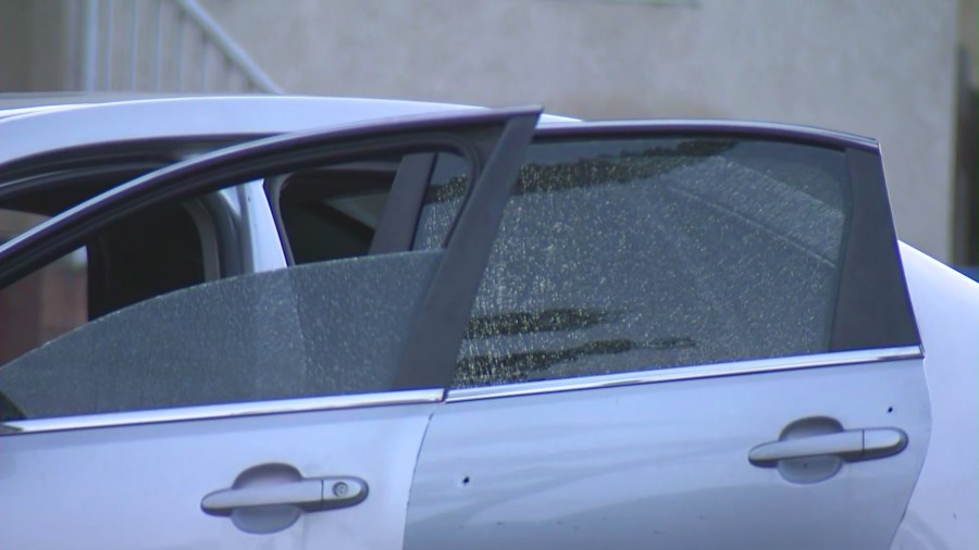 Police investigate a silver sedan with bullet holes after three people, including an infant, were hospitalized in a drive-by shooting in South L.A. on Feb. 8, 2025. (KTLA)