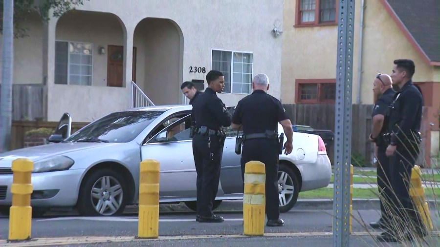 Police investigate a silver sedan with bullet holes after three people, including an infant, were hospitalized in a drive-by shooting in South L.A. on Feb. 8, 2025. (KTLA)
