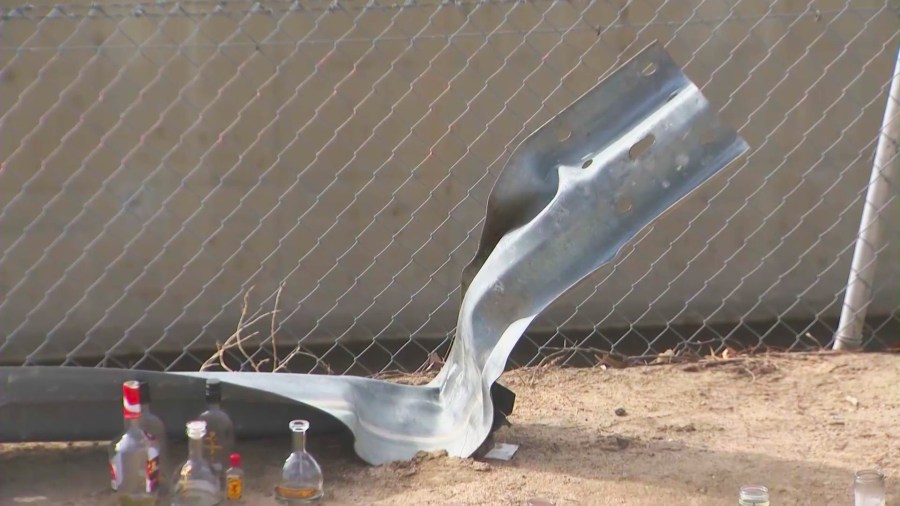 A crushed guardrail near a flood control channel at North Perris Hill Park Road and East Pacific Avenue in San Bernardino where the victims were killed. (KTLA)