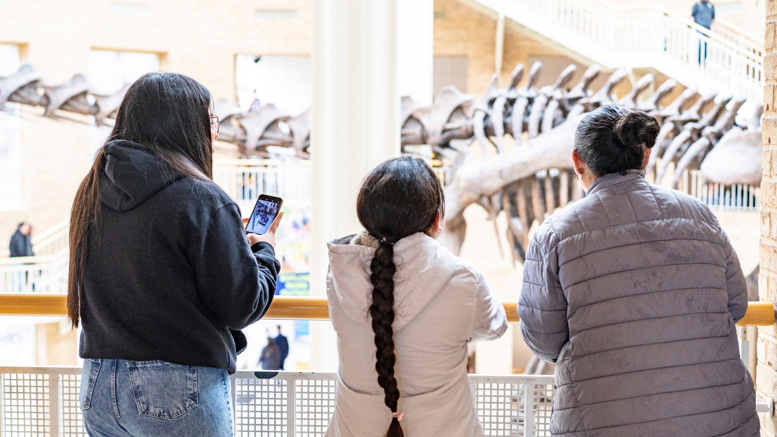 Three humanitarian parole beneficiaries from Venezuela sponsored by Sandra McAnany, enjoying a day at the Fernbank Museum, Dec. 16, 2023, in Atlanta, Ga. (Sandra McAnany via AP)