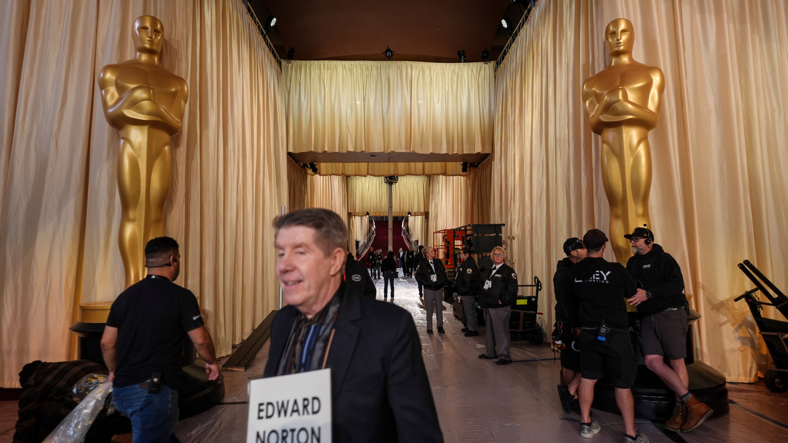 A stand-in walks past Oscar statues in the red carpet area before the 97th Academy Awards in Los Angeles, Saturday, March 1, 2025. (AP Photo/Jae C. Hong)