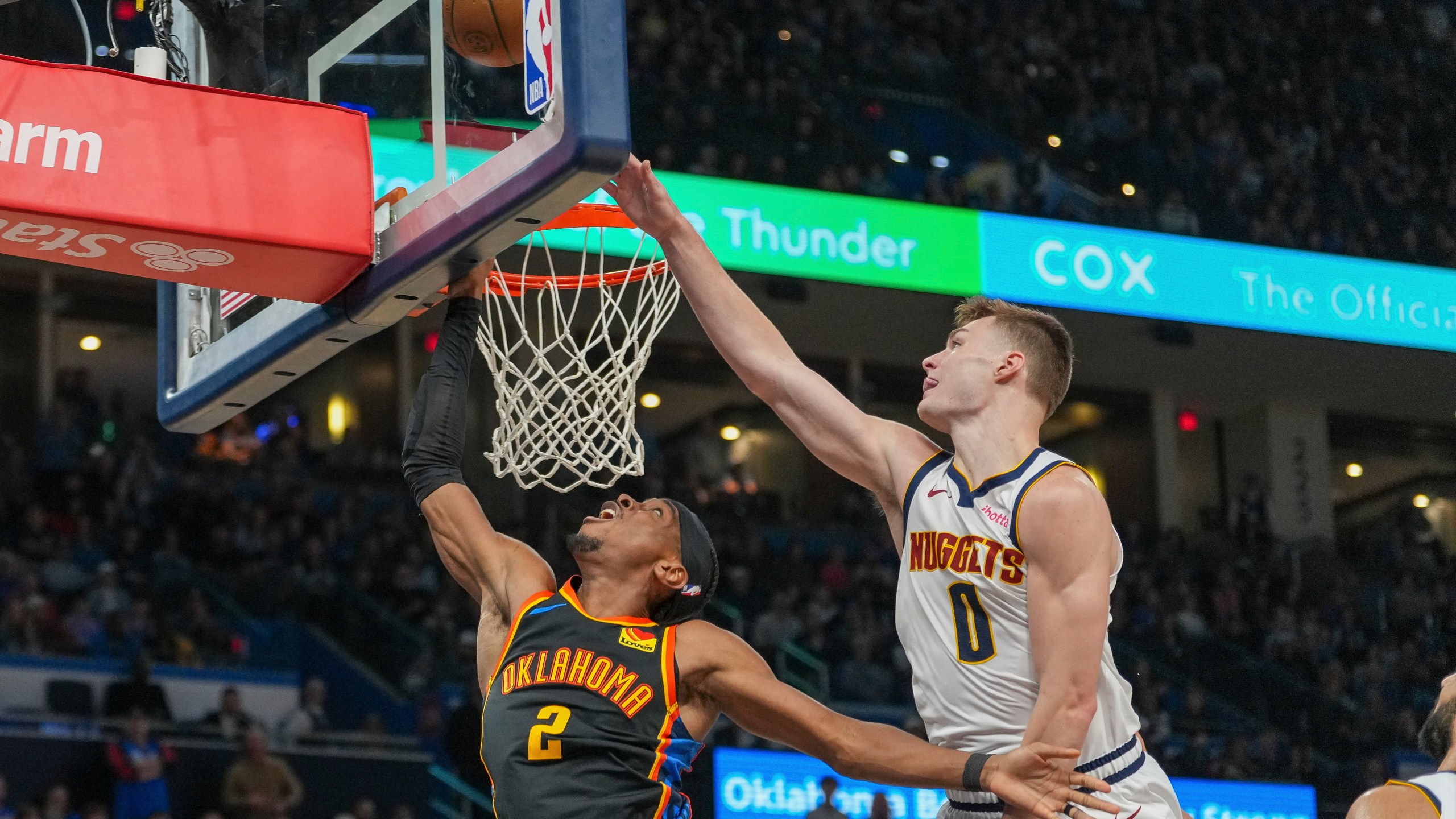 Oklahoma City Thunder guard Shai Gilgeous-Alexander (2) shoots in front of Denver Nuggets guard Christian Braun (0) during the second half of an NBA basketball game, Sunday, March 9, 2025, in Oklahoma City. (AP Photo/Kyle Phillips)