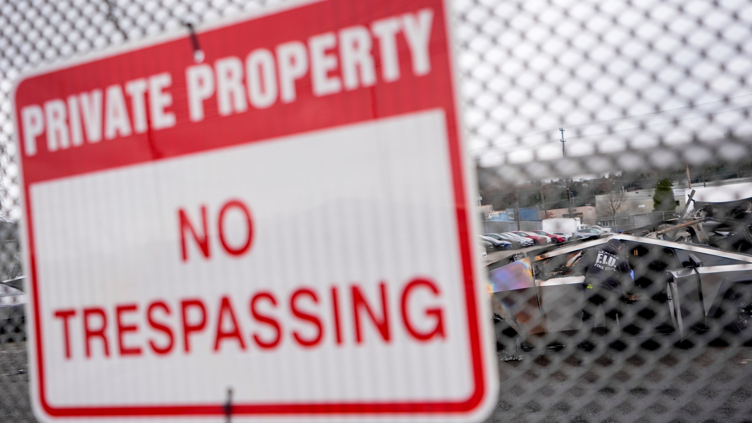 A sign hangs at the Tesla lot where Tesla Cybertrucks burned in Seattle, Monday, March 10, 2025. (AP Photo/Lindsey Wasson)