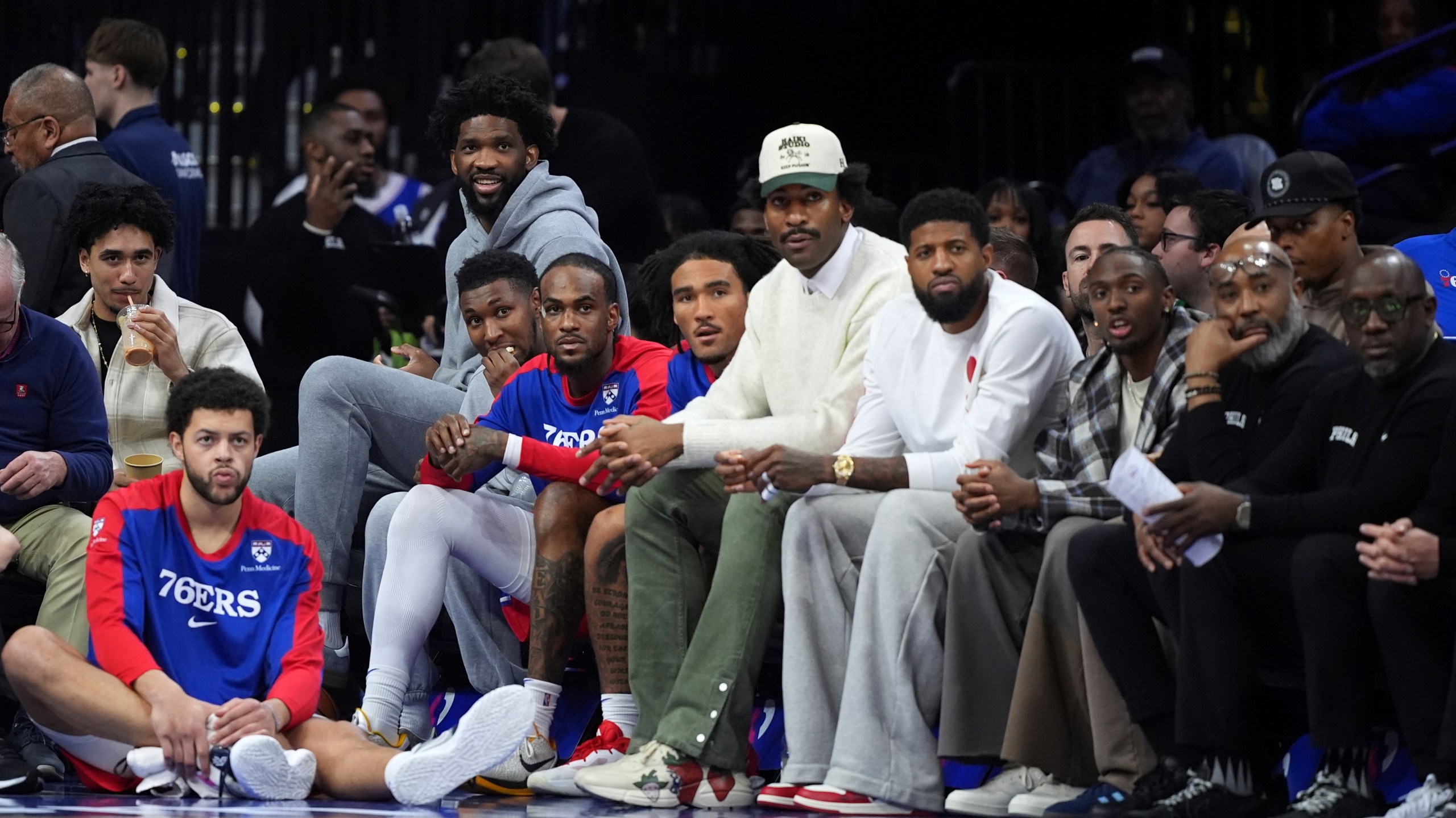 Philadelphia 76ers' Jared McCain, from left, Alex Reese, Joel Embiid, Justin Edwards, Oshae Brissett, Jalen Hood-Schifino, Andre Drummond, Paul George, Tyrese Maxey and Kyle Lowry watch from the bench during the second half of an NBA basketball game against the Indiana Pacers Friday, March 14, 2025, in Philadelphia. (AP Photo/Matt Slocum)
