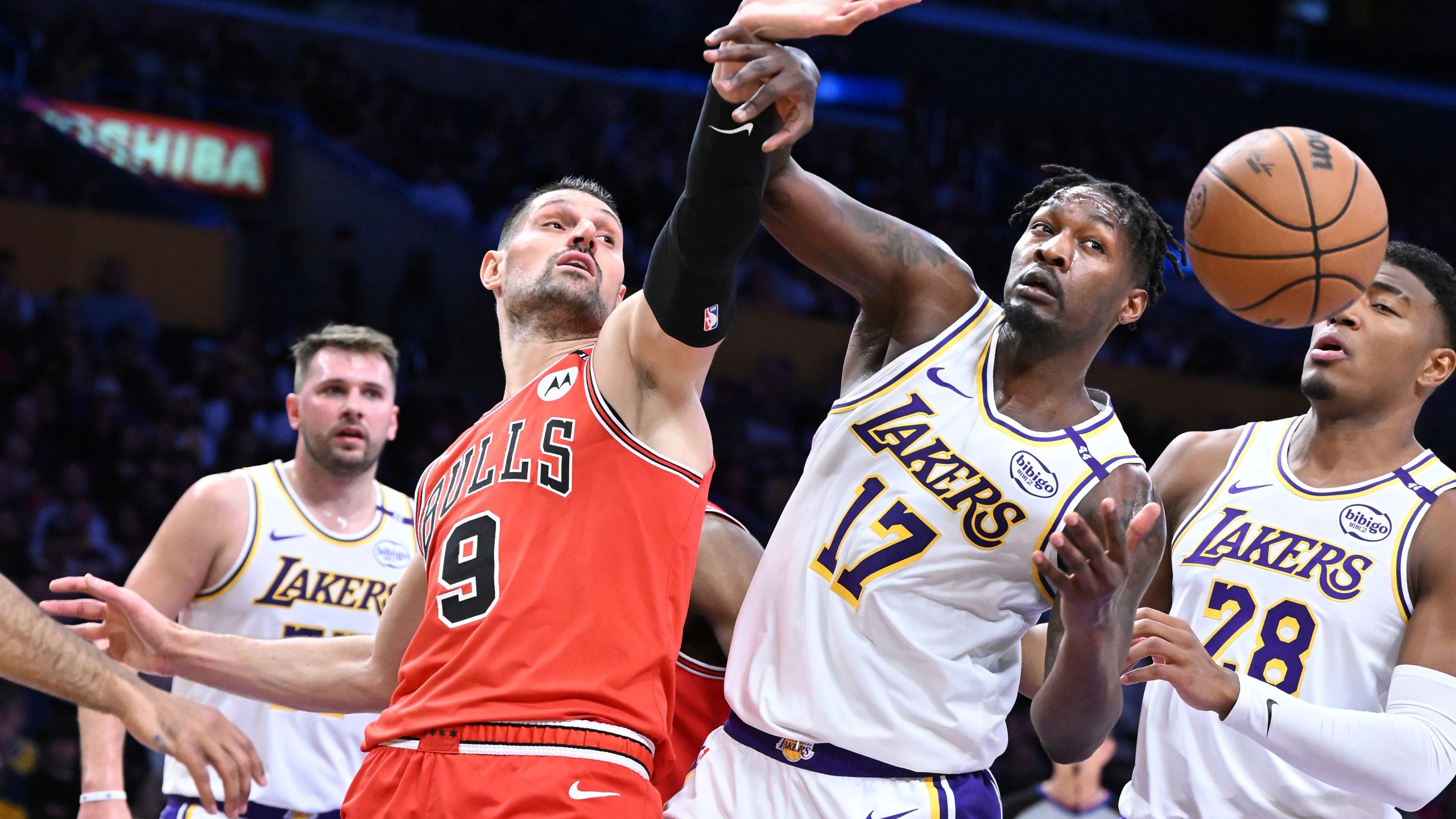 Chicago Bulls center Nikola Vucevic (9) and Los Angeles Lakers forward Dorian Finney-Smith (17) battle for a rebound in the first half of an NBA basketball game Saturday, March 22, 2025, in Los Angeles. (AP Photo/Wally Skalij)