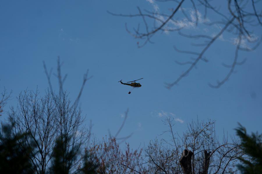 A helicopter does a water drop on the Black Cove Fire Wednesday, March 26, 2025, in Saluda, N.C. (AP Photo/Allison Joyce)