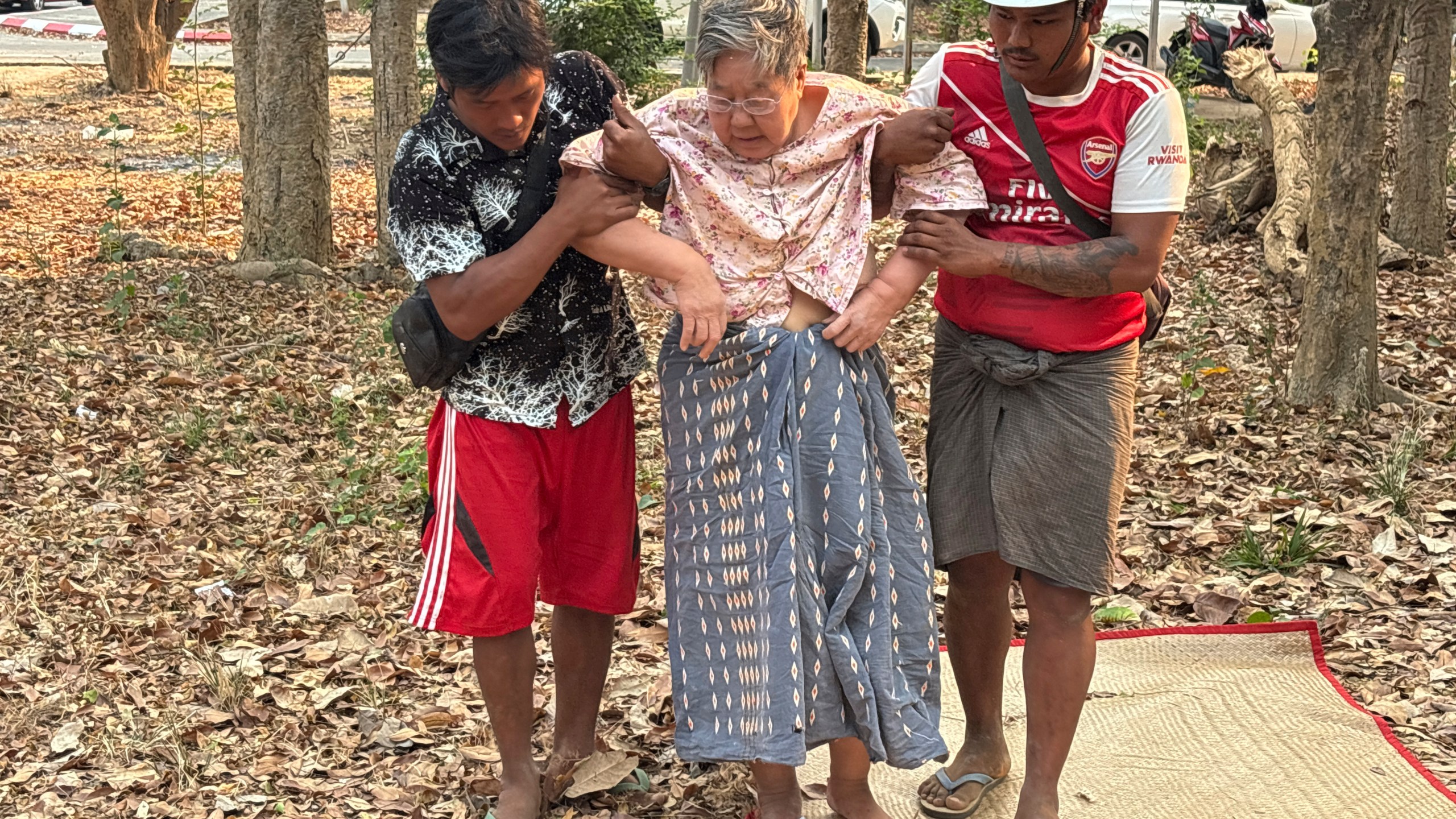 Rescue workers help an injured women who was trapped under a building Friday, March 28, 2025, in Naypyitaw, Myanmar. (AP Photo/Aung Shine Oo)