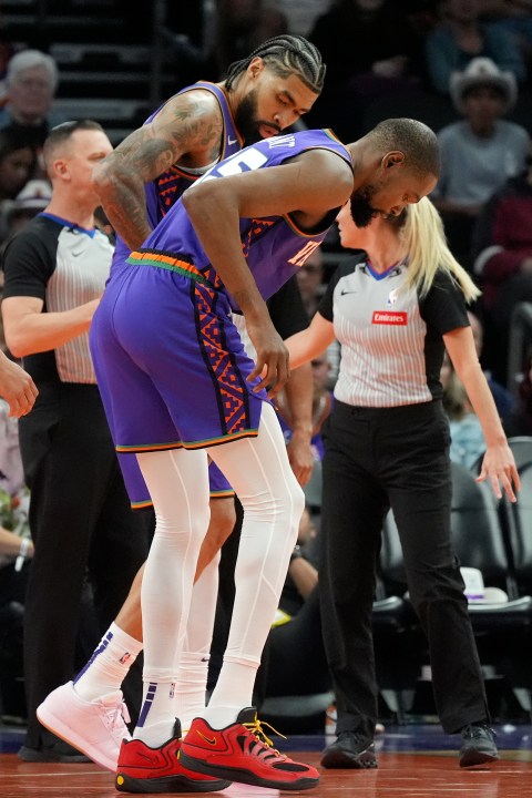 Phoenix Suns forward Kevin Durant, right, limps off the court due to an injury as Suns center Nick Richards, back left, looks on during the second half of an NBA basketball game against the Houston Rockets Sunday, March 30, 2025, in Phoenix. (AP Photo/Ross D. Franklin)