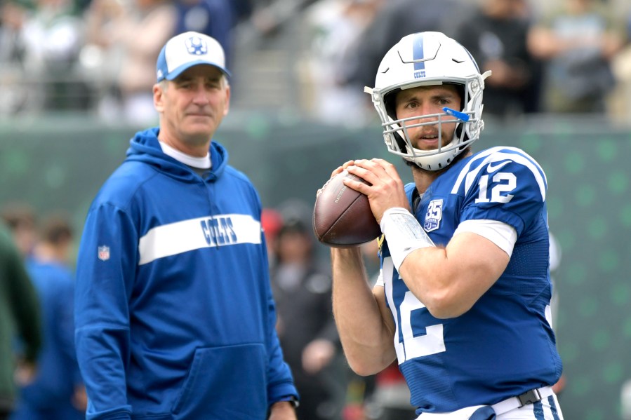 FILE - Indianapolis Colts quarterback Andrew Luck (12) warms up as head coach Frank Reich looks on prior to an NFL football game against the New York Jets, in East Rutherford, N.J, Oct. 14, 2018. (AP Photo/Bill Kostroun, File)