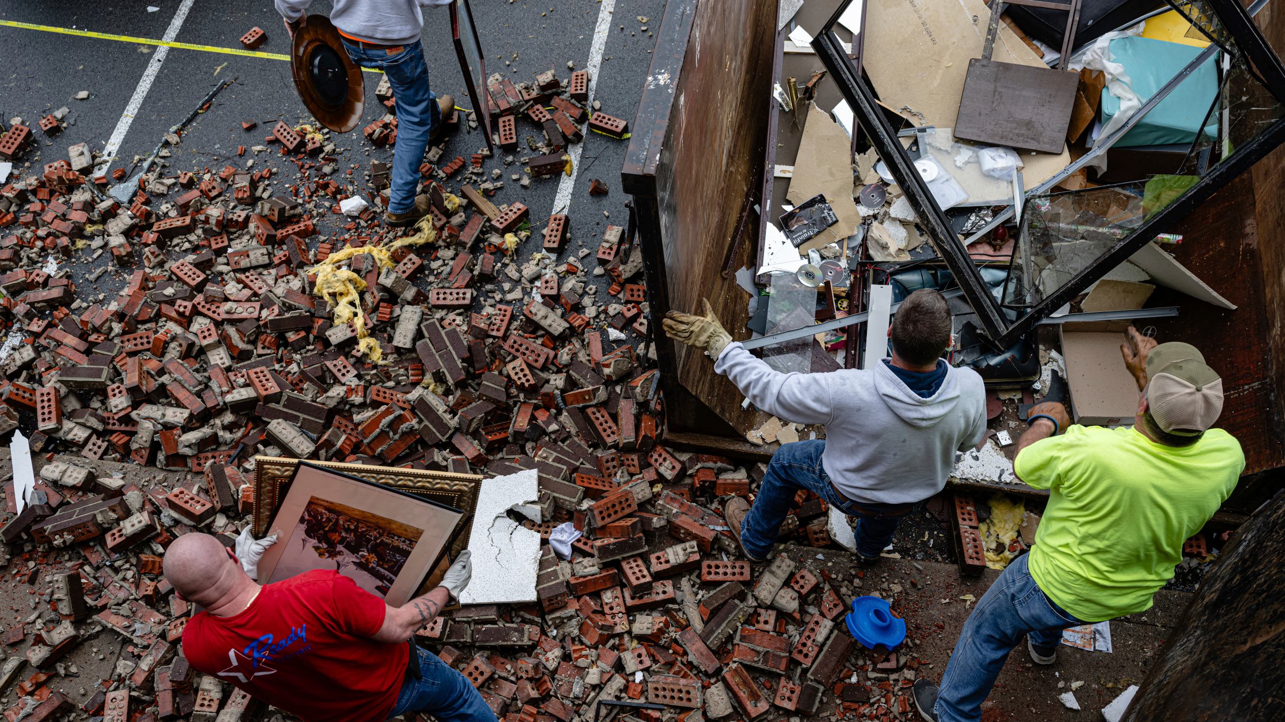People remove debris from a damaged business in the Triad Building, a business plaza, after severe weather passed through on Thursday, April 3, 2025, in Louisville, Ky. (AP Photo/Jon Cherry)