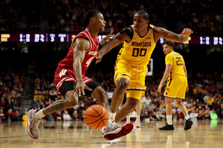 Wisconsin guard Kamari McGee (4) drives toward the hoop while Minnesota forward Frank Mitchell (00) defends during the second half of an NCAA college basketball game, Wednesday, March 5, 2025, in Minneapolis. (AP Photo/Ellen Schmidt)