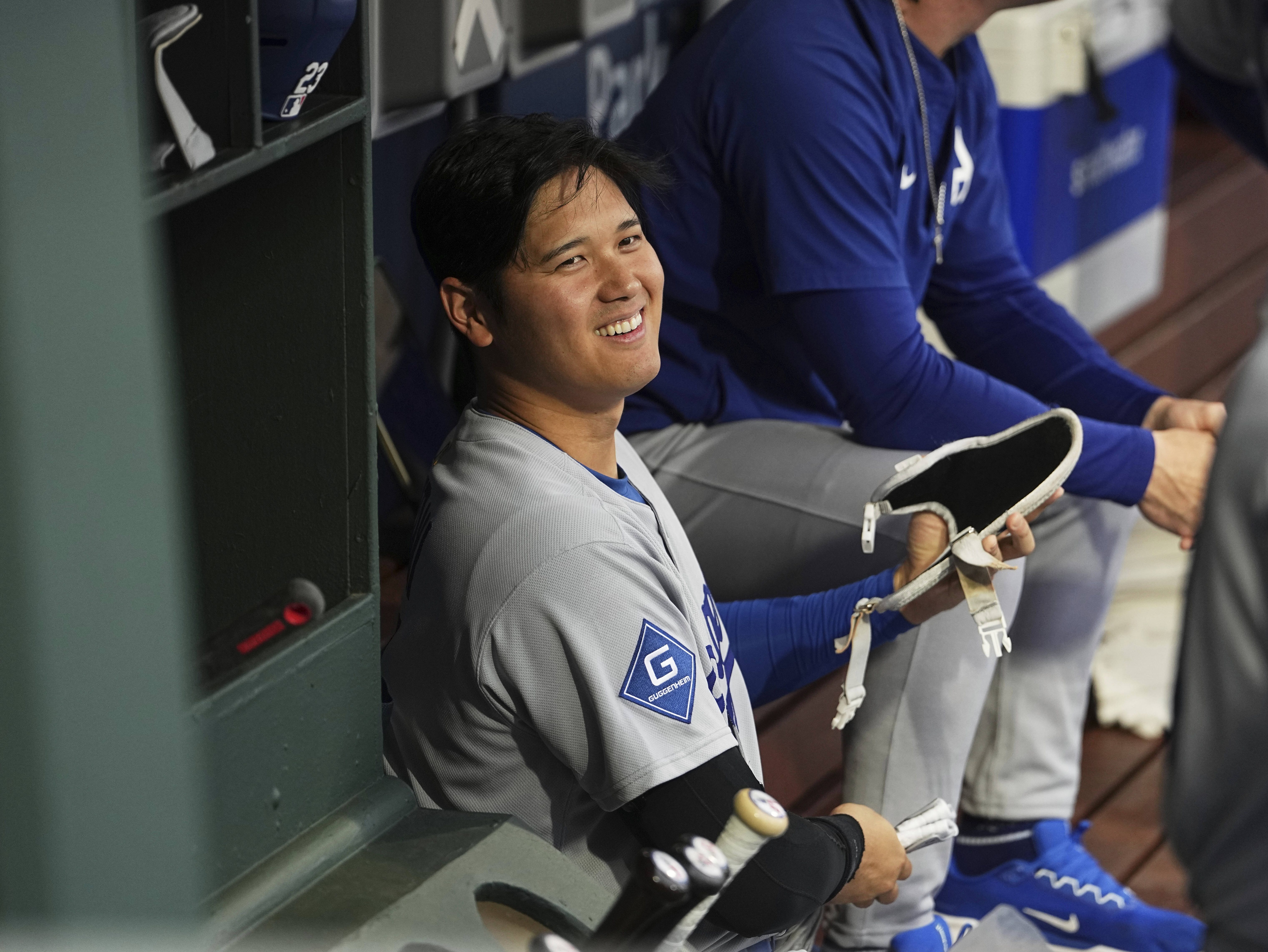 Los Angeles Dodgers' Shohei Ohtani smiles in the dugout ahead of a baseball game against the Philadelphia Phillies, Friday, April 4, 2025, in Philadelphia. (AP Photo/Matt Rourke)