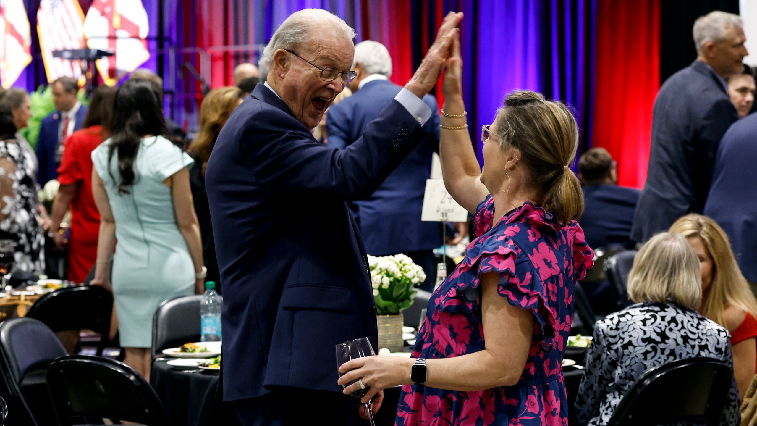 Alabama Sen. Jabo Waggoner, left, high fives a guest as they wait for Donald Trump Jr. to speak at the Alabama Republican Party's Trump Victory Celebration, Thursday, April 3, 2025, in Birmingham, Ala. (AP Photo/Butch Dill)