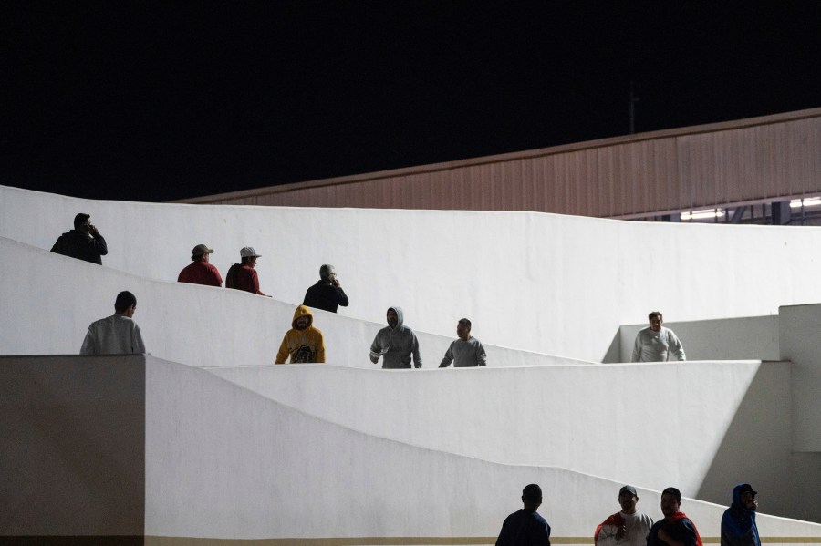 Migrants walk into Mexico after being deported from the United States at El Chaparral pedestrian border bridge in Tijuana, Mexico, Jan. 21, 2025. (AP Photo/Felix Marquez)