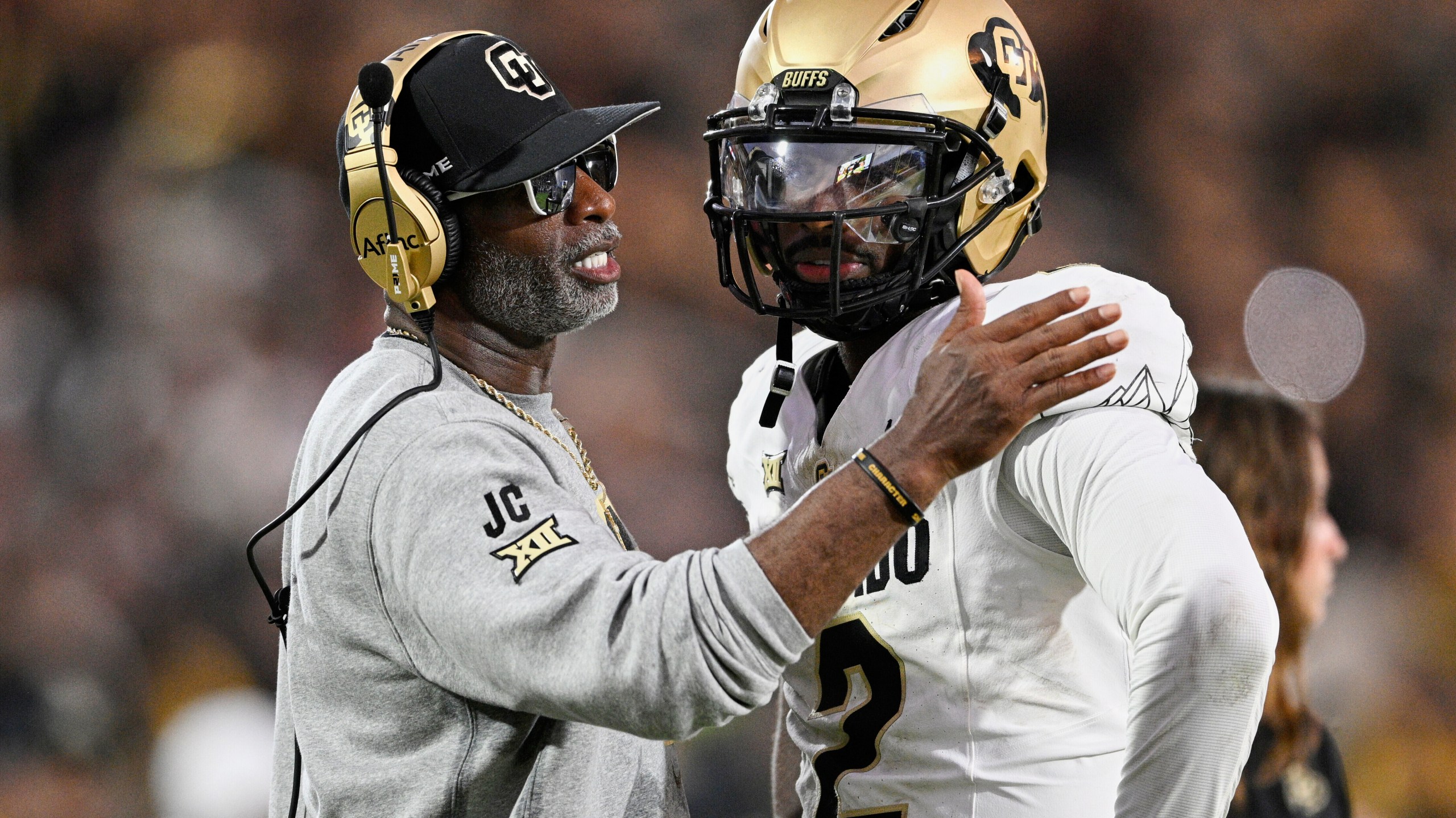 FILE - Colorado head coach Deion Sanders, left, talks with quarterback Shedeur Sanders (2) during a timeout in the second half of an NCAA college football game against Central Florida, Saturday, Sept. 28, 2024, in Orlando, Fla. (AP Photo/Phelan M. Ebenhack, File)