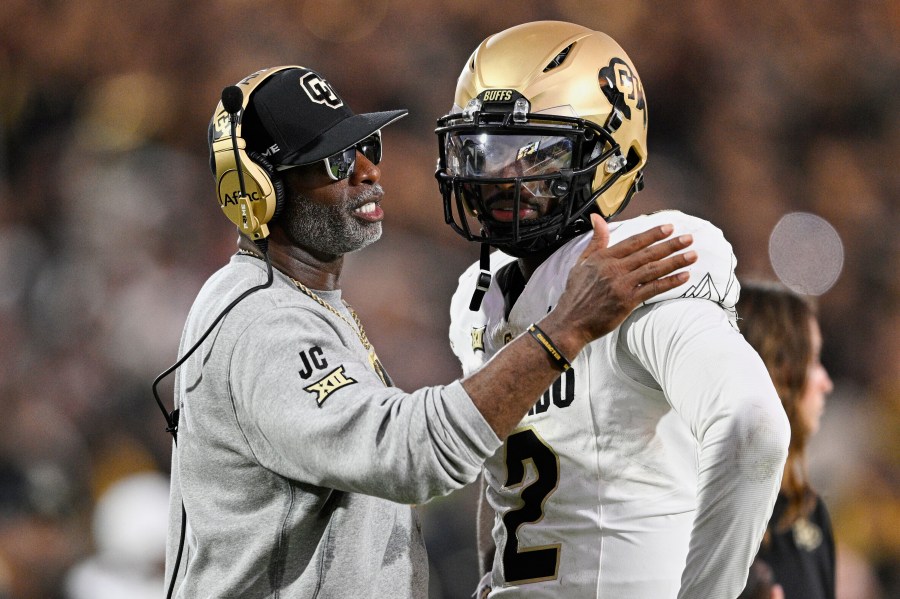 FILE - Colorado head coach Deion Sanders, left, talks with quarterback Shedeur Sanders (2) during a timeout in the second half of an NCAA college football game against Central Florida, Saturday, Sept. 28, 2024, in Orlando, Fla. (AP Photo/Phelan M. Ebenhack, File)
