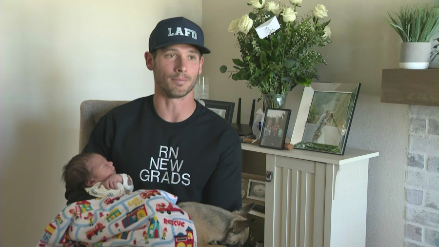 Matt Okula speaks to KTLA while holding baby Crew. (KTLA)
