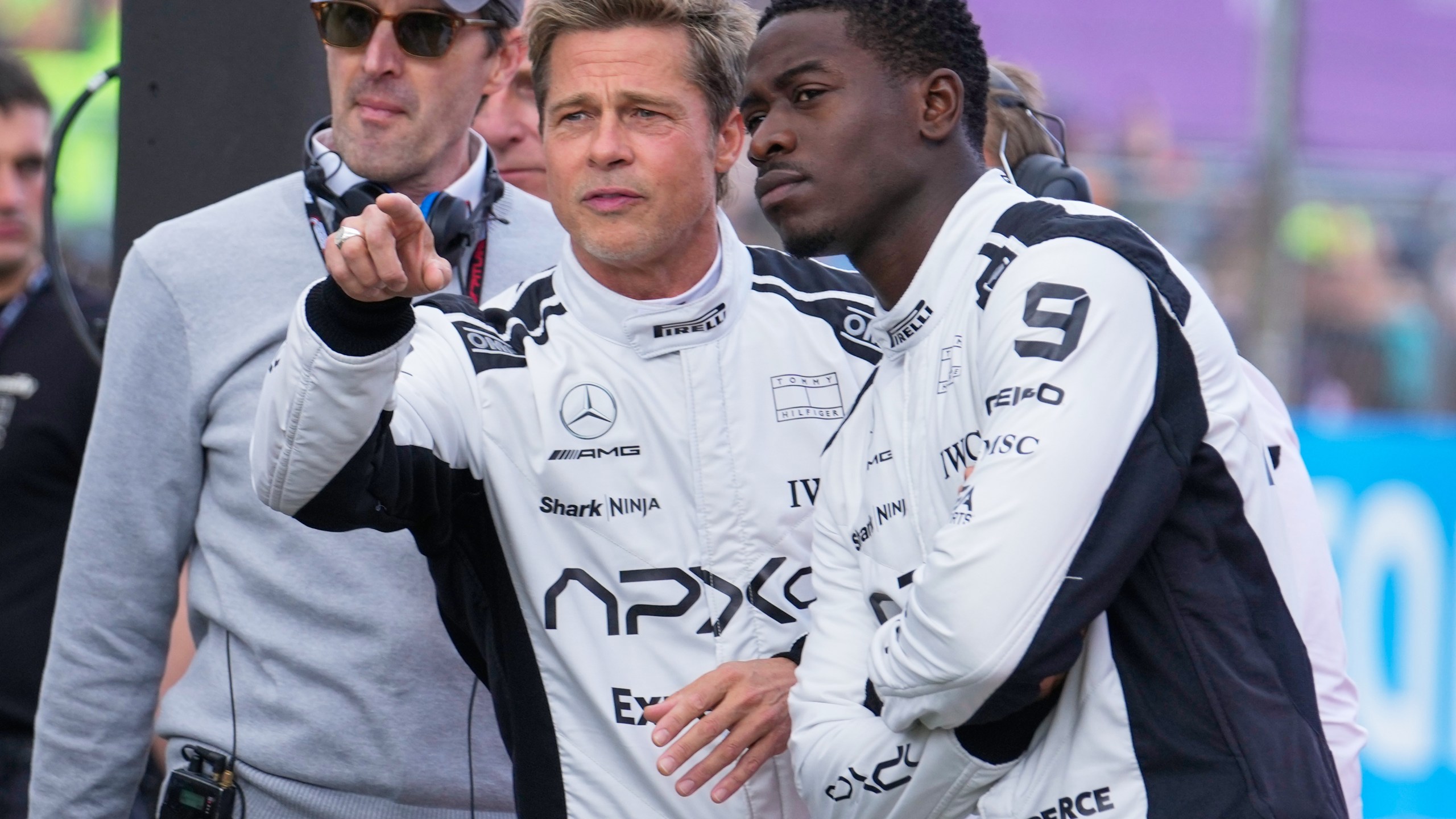 FILE - Actors Brad Pitt, left, and Damson Idris appear on the grid before the British Formula One Grand Prix race at the Silverstone racetrack, Silverstone, England, on July 9, 2023, for the filming of "F1." (AP Photo/Luca Bruno, File)