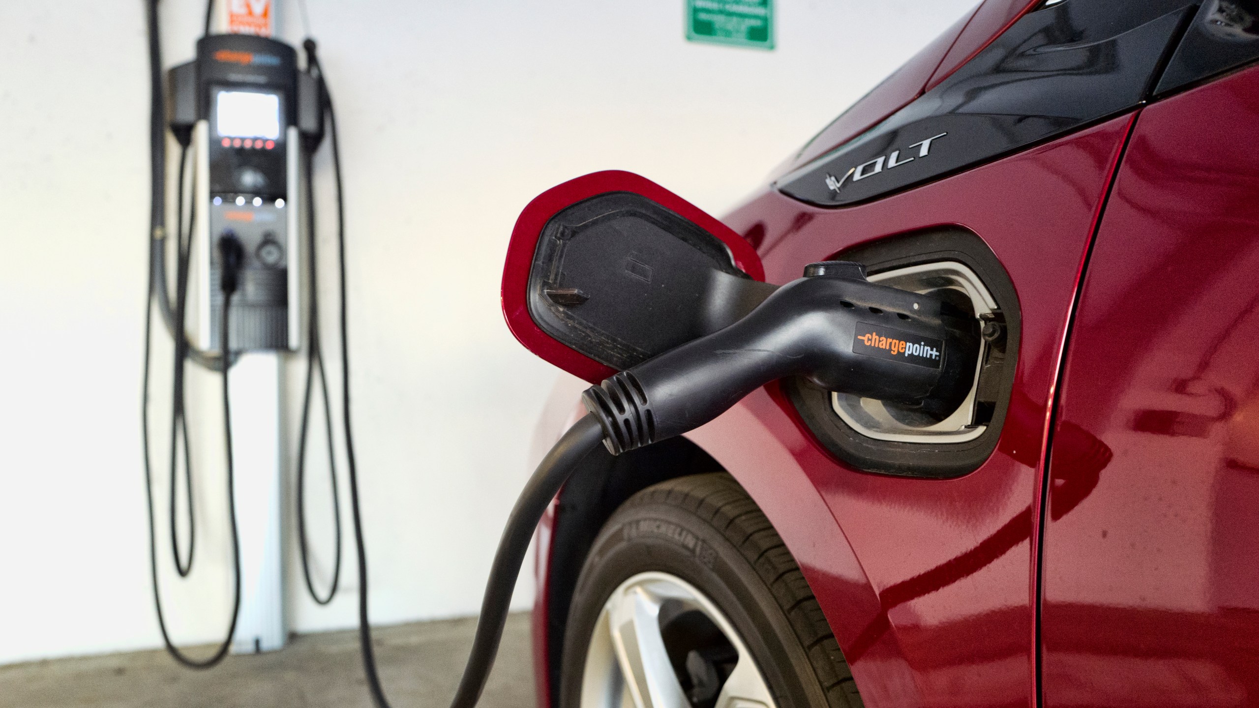 FILE - A Chevrolet Volt hybrid car is seen charging at a ChargePoint charging station at a parking garage in Los Angeles, Oct. 17, 2018. (AP Photo/Richard Vogel, File)