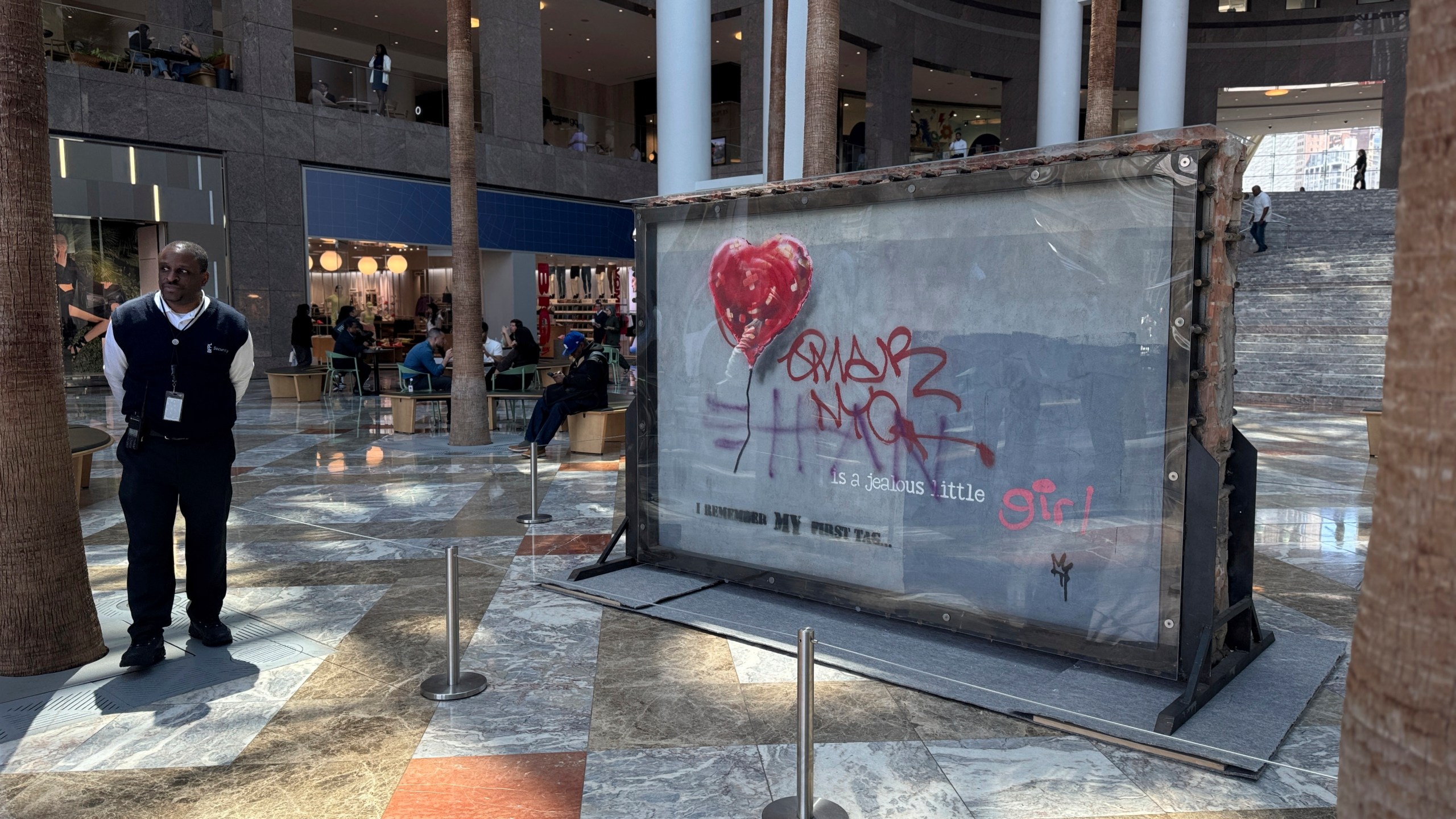 A slab of wall art, The "Battle to Survive a Broken Heart,' created by the artist Banksy, sits on display inside the Brookfield Place atrium, Tuesday, April 29, 2025, in New York. The nearly four-ton piece will be auctioned off on May 21. (AP Photo/Julie Jacobson)