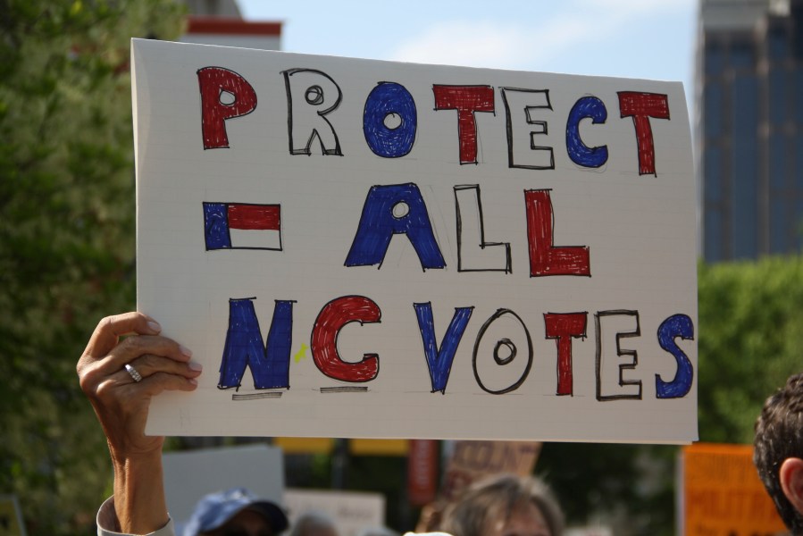 A protester listens to speeches during a rally for Democratic Associate Justice Allison Riggs in Raleigh, N.C., on Monday, April 14, 2025. (AP Photo/Makiya Seminera)