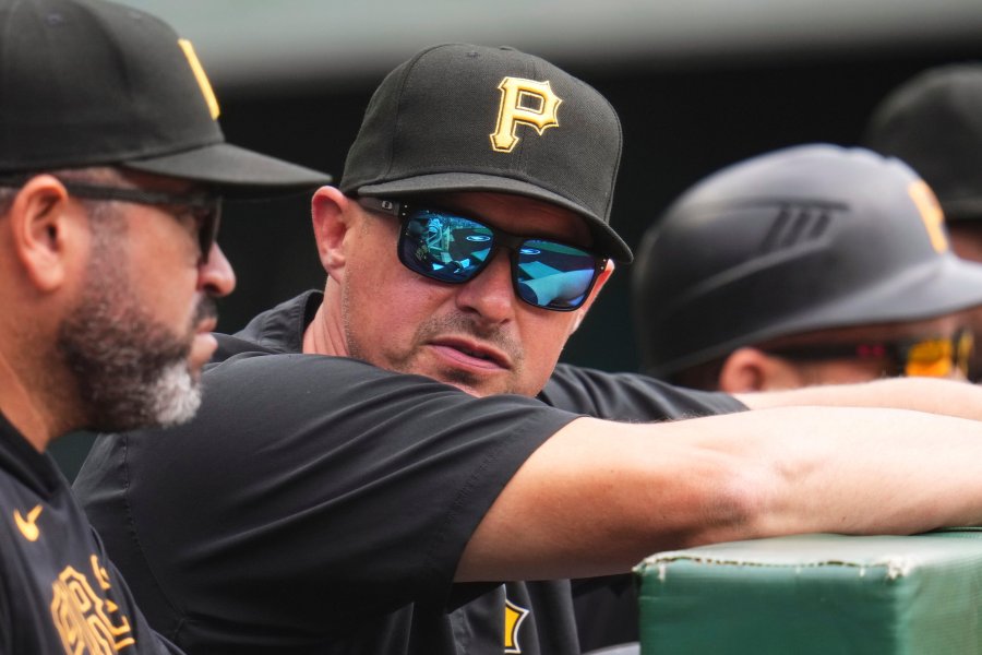 Pittsburgh Pirates bench coach Don Kelly, center, stands in the dugout with pitching coach Oscar Marin during a baseball game against the Chicago Cubs in Pittsburgh, Thursday, May 1, 2025. (AP Photo/Gene J. Puskar)