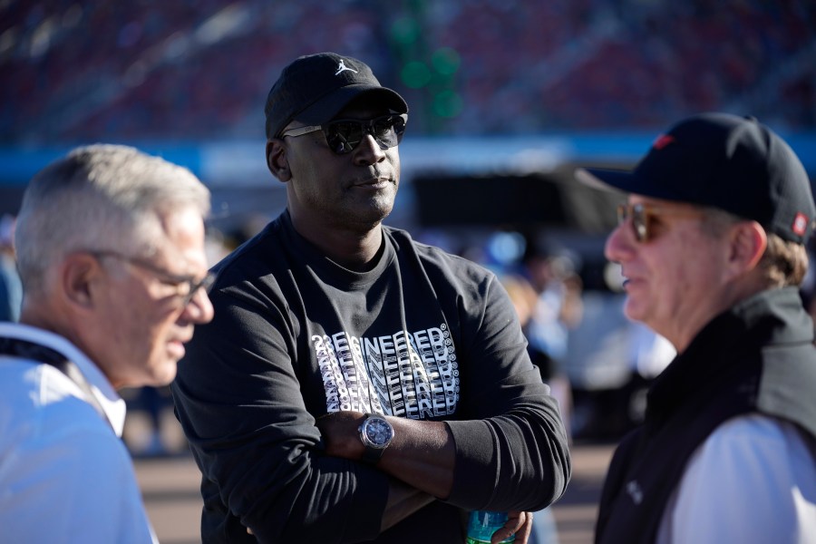 FILE - Michael Jordan, center, and Curtis Polk, left, co-owners of 23XI Racing, watch during qualifying beside 23XI Racing President Steve Lauletta, right, for a NASCAR Cup Series Championship auto race, Nov. 9, 2024, in Avondale, Ariz. (AP Photo/John Locher, file)