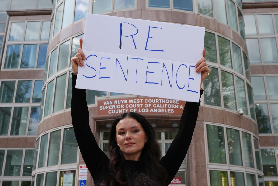 Natasha Blasick holds a sign in support of Erik and Lyle Menendez outside the Van Nuys Courthouse during a hearing in the brothers' case Tuesday, May 13, 2025, in Los Angeles. (AP Photo/Damian Dovarganes)