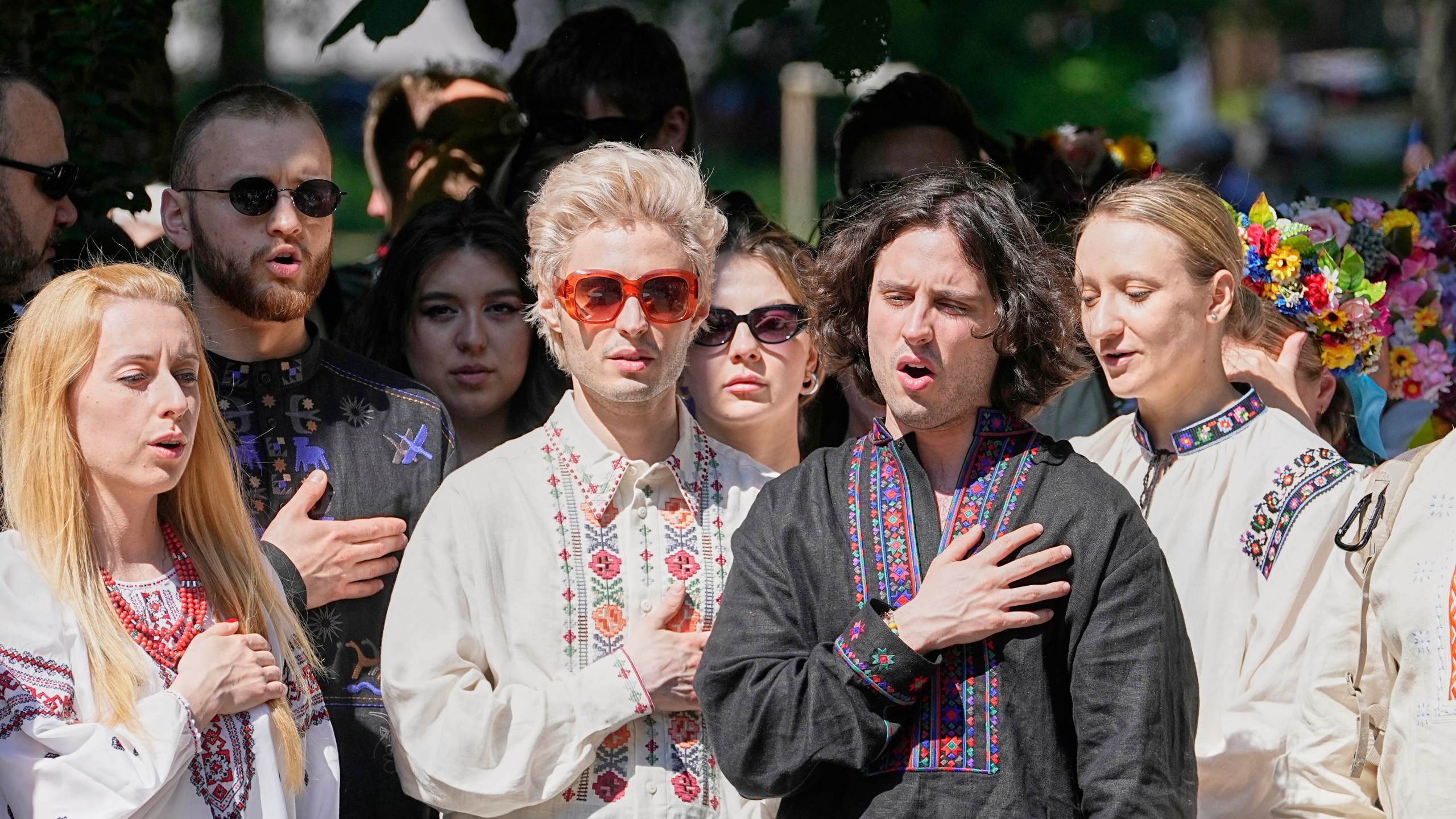 Eurovision band Ziferblat of Ukraine sings their national anthem with Ukrainian people during a family meeting in a park in Basel as part of the 69th Eurovision Song Contest week, in Basel, Switzerland, Thursday, May 15, 2025. (AP Photo/Martin Meissner)